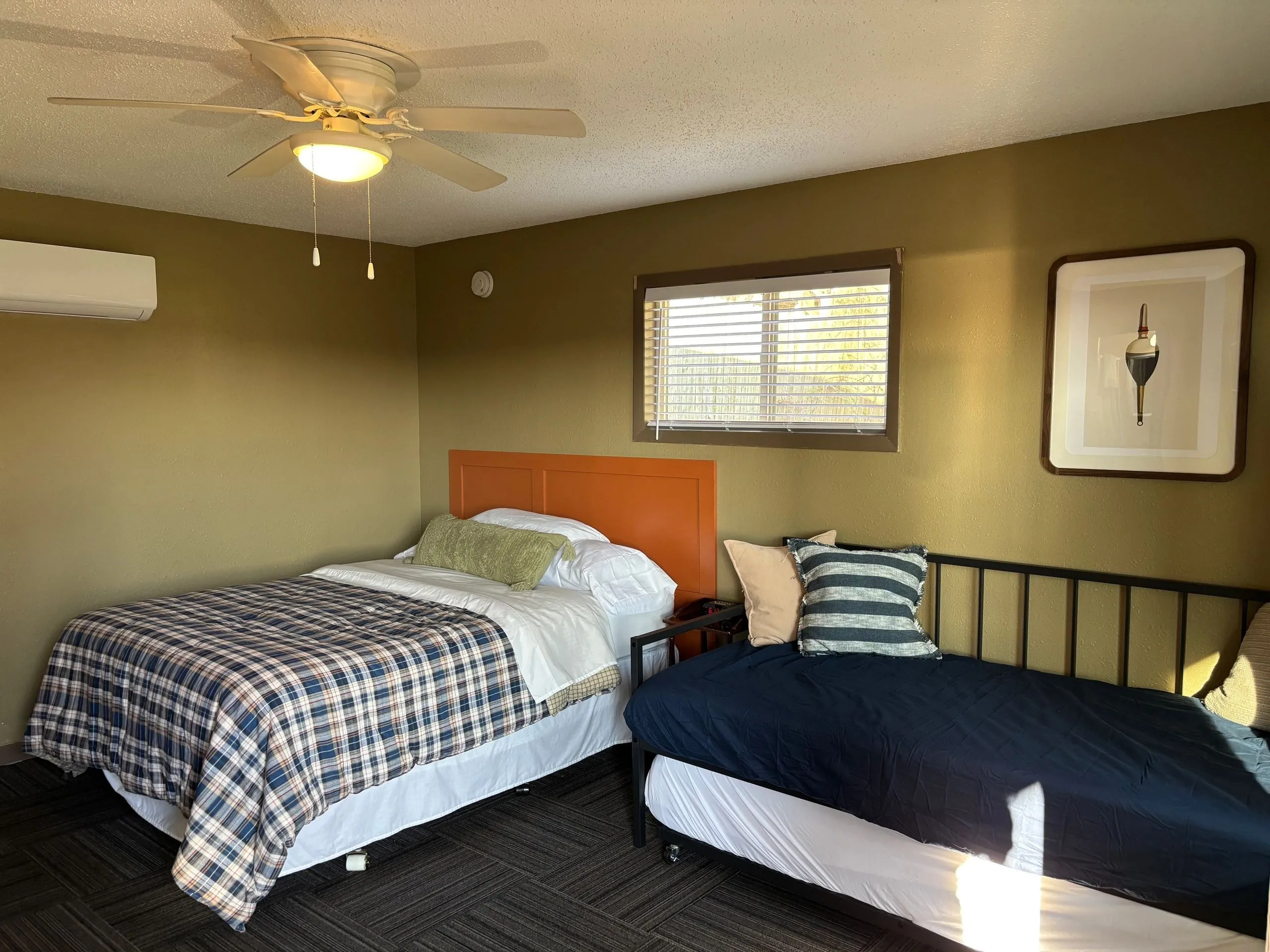 Queen bed and single bed with the window and air conditioning unit