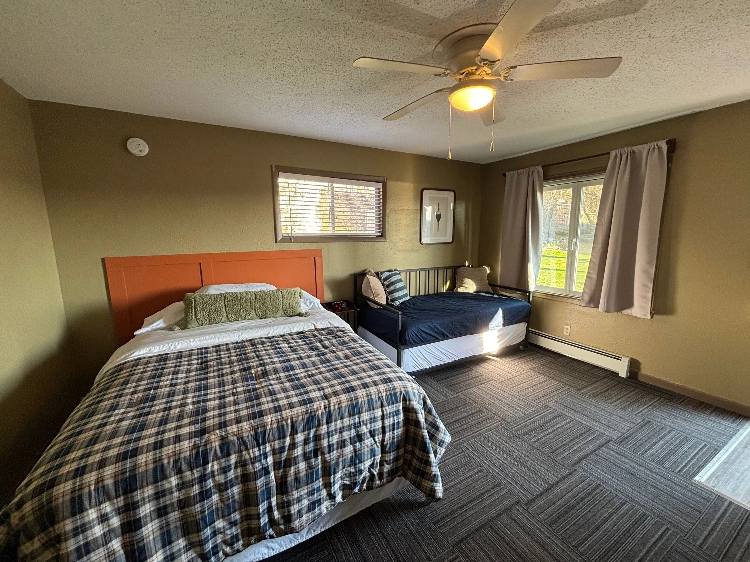 The room looking toward the windows, queen and single beds